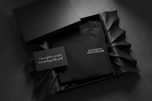 give me a black tee folded…upper left chest elite petty with posture. all caps small font size. place inside a black box, hald folded with black tissue paper. add an affirmstion card (u choose words). 